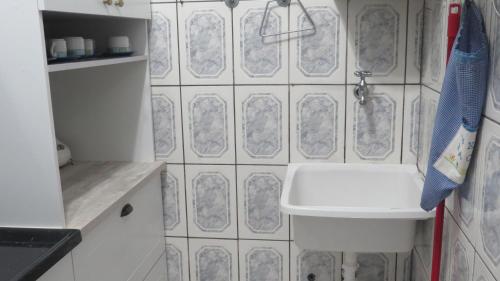卡拉瓜塔图巴Apartamento Pé na Areia的浴室设有白色水槽和白色瓷砖