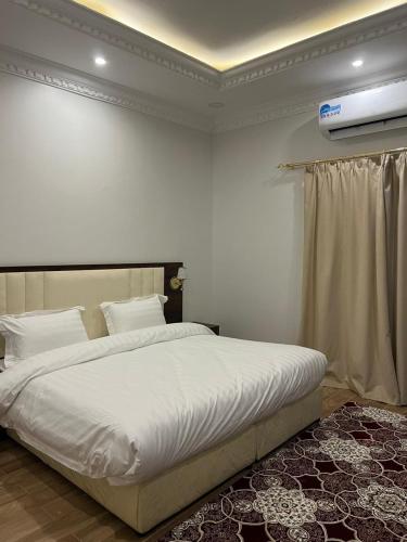 延布أحلى الليالي للشقق الفندقية的一间卧室配有一张带白色床单的大床