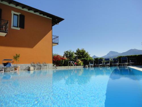 梅纳焦阿德勒酒店的一座带椅子的大型游泳池和一座建筑