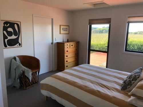 KaitunaRyland Estate Guest Apartment的一间卧室配有一张床、一个梳妆台和一扇窗户。