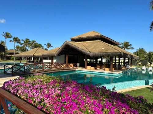 弗雷谢拉斯Bangalô Eco Residence Flecheiras的一个带紫色花卉游泳池的度假酒店