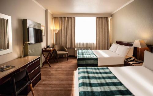 金伯利Garden Court Kimberley的酒店客房设有两张床和电视。