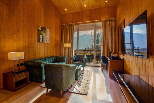 马拉里Palchan Hotel & Spa - A member of Radisson Individuals Retreats的客厅设有绿色沙发和大窗户