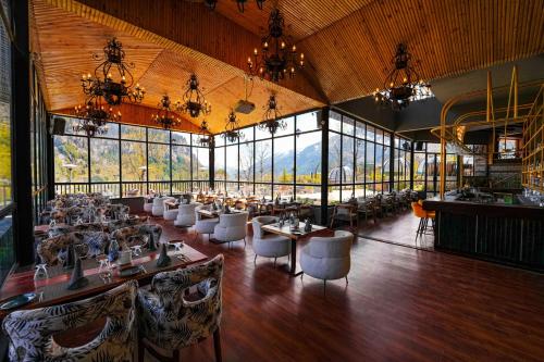 马拉里Palchan Hotel & Spa - A member of Radisson Individuals Retreats的用餐室设有桌椅和窗户。