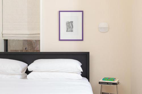 费城YOWIE Hotel的一张带白色枕头的床和一张墙上的照片
