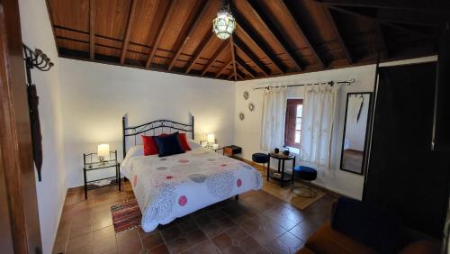 La Tierra del TrigoCASA TIO MANUEL的一间卧室配有一张带红色枕头的床