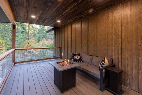 莱文沃思Bear Den a Cozy 1 Bedroom tiny Cabin near Lake Wenatchee的门廊上设有沙发和火坑的屏风