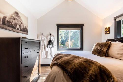 莱文沃思Bear Den a Cozy 1 Bedroom tiny Cabin near Lake Wenatchee的一间卧室配有一张床、一个梳妆台和一扇窗户。