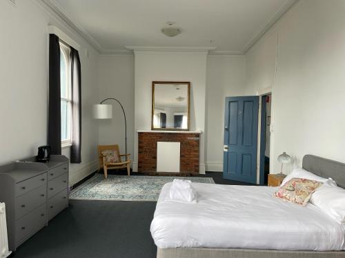墨尔本College Lawn Hotel的一间卧室配有一张床、梳妆台和镜子
