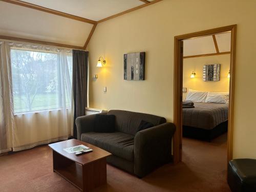 马斯特顿Masterton Motor Lodge的带沙发、床和镜子的客厅