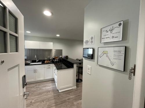 夏洛茨维尔Sonsak - Unit 5的厨房配有白色橱柜和黑色台面