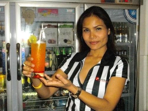 芭堤雅市中心我流浪者酒店的冰箱前喝着饮料的女人