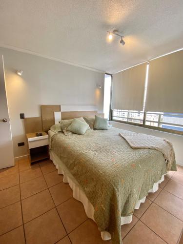 伊基克Departamento Sector Turístico (Cavancha)的一间卧室设有一张大床和一个大窗户