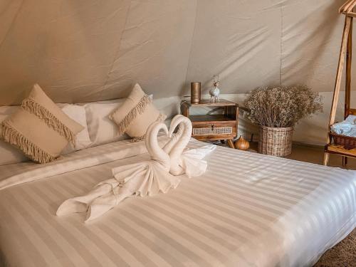 卡塔海滩Greenheart garden View Camp phuket的一张白色的床,上面有两条天鹅绒毛巾