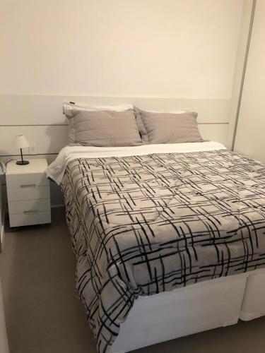 圣保罗皇家伊比拉普埃拉公园公寓的一间卧室配有一张带黑白色棉被的床