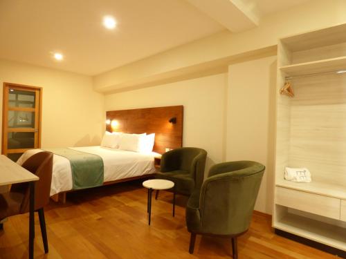 TalaveraMuña Hotel的酒店客房,配有一张床和两把椅子