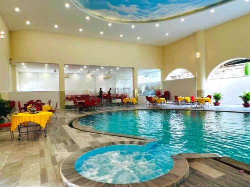朔庄Quê Tôi Hotel的一座配有桌椅的酒店游泳池