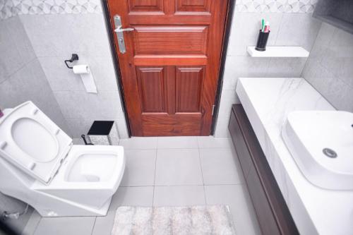 坎帕拉PearlCrest townhomes的一间带卫生间、水槽和门的浴室