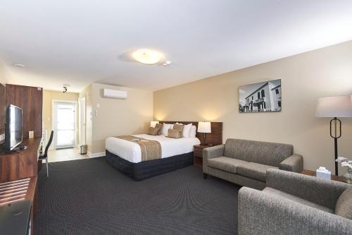 罗托鲁瓦Newina Rotorua的酒店客房配有床、沙发和电视。