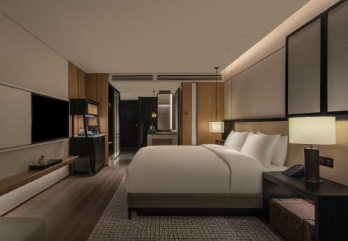 北京北京华侨大厦睿世酒店的卧室配有一张白色大床和电视。