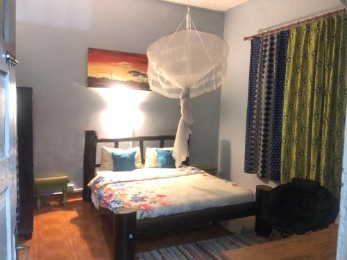MbaleSarah’s place的一间卧室配有一张床和一个吊灯