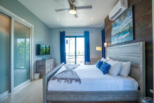 珀拉什奇亚Sunset Gecko Condos Entire Property的一间卧室配有一张带蓝色墙壁的大床