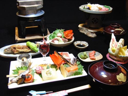 白川村Oyado Yunosato的餐桌,餐盘和一杯葡萄酒