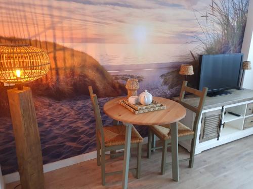 滨海卡特韦克't Hoekhuisje的一间带桌子和电视的用餐室