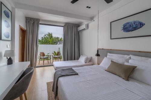 福拉杜岛Villa Mia Fulhadhoo的白色卧室配有床和桌椅