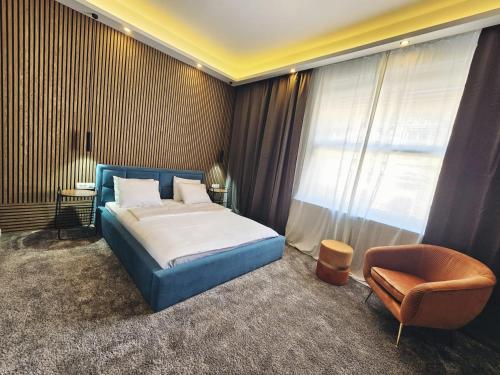 萨格勒布B&B Cvjetni的卧室配有床、椅子和窗户。