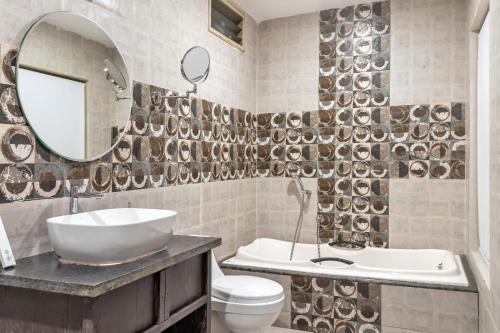 莫尔吉姆Skon Morjim Beach Resort by Orion Hotels的一间带水槽、卫生间和镜子的浴室