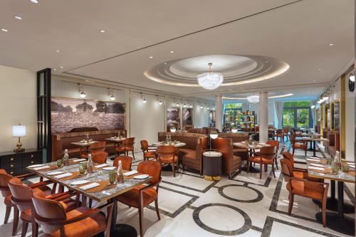 艾哈迈达巴德ITC Narmada, a Luxury Collection Hotel, Ahmedabad的一间在房间内配有桌椅的餐厅