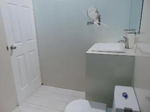 坎昆Departamentos Villas Capdeviel的白色的浴室设有卫生间和水槽。