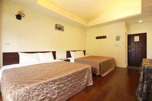 Guoxing後頭厝民宿的一间酒店客房,设有两张床和一扇门