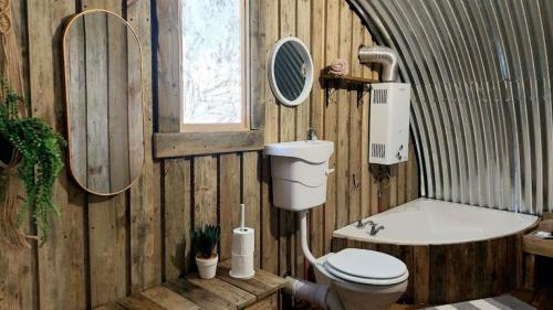 戈登湾11 Mountain Stream Hot Tub Self Catering的木制浴室设有卫生间和浴缸