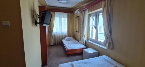 巴尼亚卢卡Rio apartments的客房设有两张床、一台电视和一扇窗户。