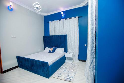 达累斯萨拉姆Niwa Apartments的蓝色的卧室,配有床和蓝色的墙壁