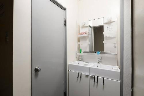大阪Backstage Party Hostel & Bar的浴室设有2个水槽和镜子