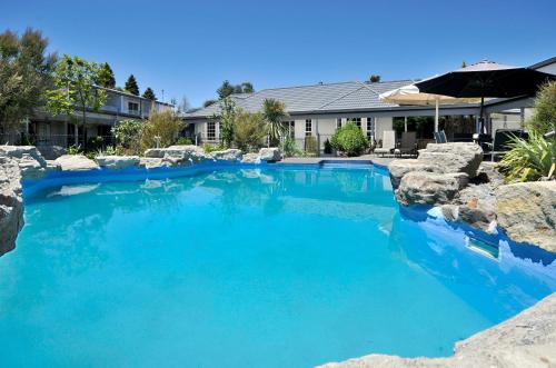 罗托鲁瓦围邑湖滨spa度假酒店的庭院里的一个蓝色海水游泳池