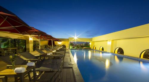胡志明市莫尔珀尔水晶宫酒店的夜间酒店带桌椅的游泳池