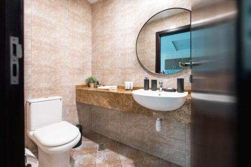 迪拜Charming Condo With Balcony In The Heart of JLT的一间带卫生间、水槽和镜子的浴室