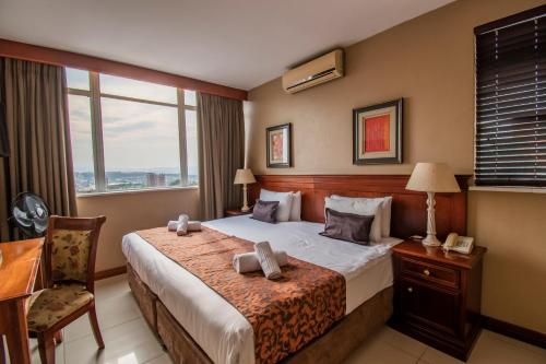 德班伊马克霍斯尼东部酒店的配有一张床、一张书桌和一扇窗户的酒店客房