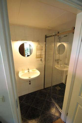 LuttenKarin's kruidenhoeve appartement Goudsbloem的一间带两个水槽和玻璃淋浴间的浴室