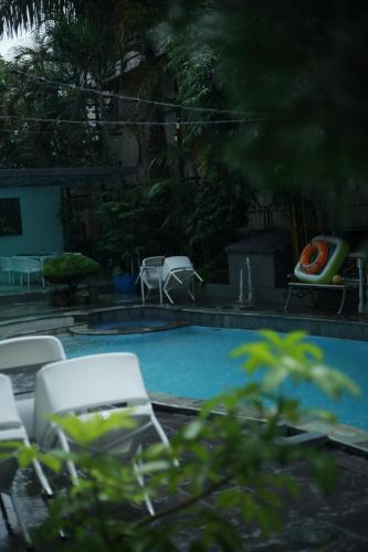博卡拉Swapnabagh Hotel & Resort的一个带椅子和桌子的游泳池以及一个壁炉