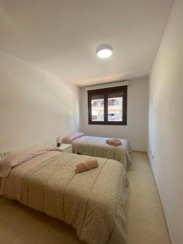 贝尼卡西姆Mirador dels Terrers的一间卧室设有三张床和窗户。