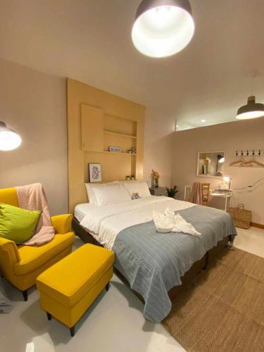 北碧Por poshtel Kanchanaburi的一间卧室配有一张大床和一张黄色椅子