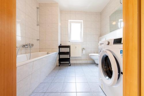 埃默里希Stay & Work - 6 single beds - central的白色的浴室内配有洗衣机。