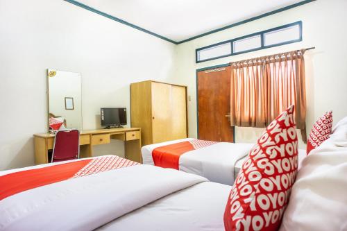 LhokseumaweOYO 1636 Wisma Kuta Karang的酒店客房配有两张床和一张书桌