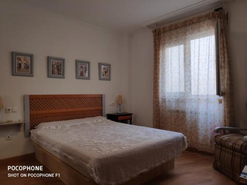 里瓦德奥La Mariña的一间卧室设有一张床和一个窗口