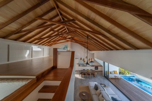 福拉杜岛Villa Mia Fulhadhoo的一间带木制天花板和游泳池的客厅